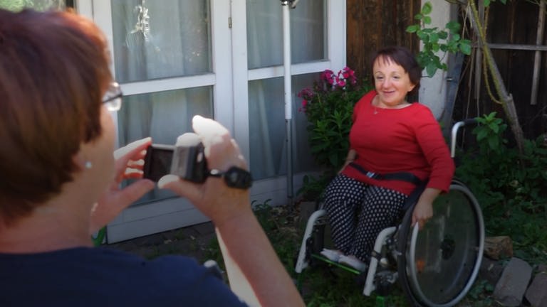 Frau im Rollstuhl vor der Kamera