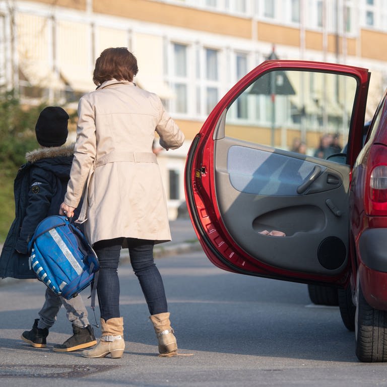 Eine Mutter bringt ihr Kind mit dem Auto zur Schule (Archiv)